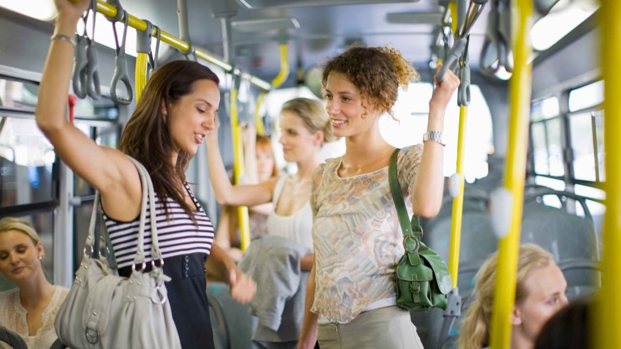 Shy girl talking to friend on bus